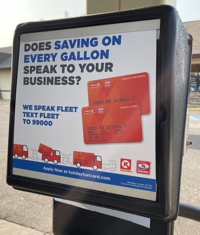 A paper towel dispenser in a gas pumping area with an ad on it promoting Holiday Stationstores’ texting list for truck fleet fuel cards.